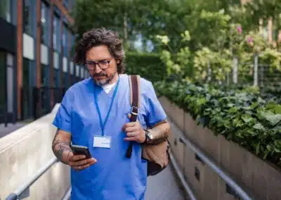 doctor,in,uniform,going,home,from,work,,texting,on,smartphone.